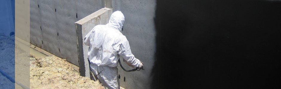 waterproofing being sprayed onto the foundation of a house
